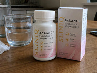 Баночка с упаковкой Sliniq balance и стаканом с воды на столе.
